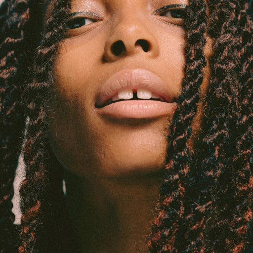 Language brand lifestyle image: close-up portrait framed by braided hair